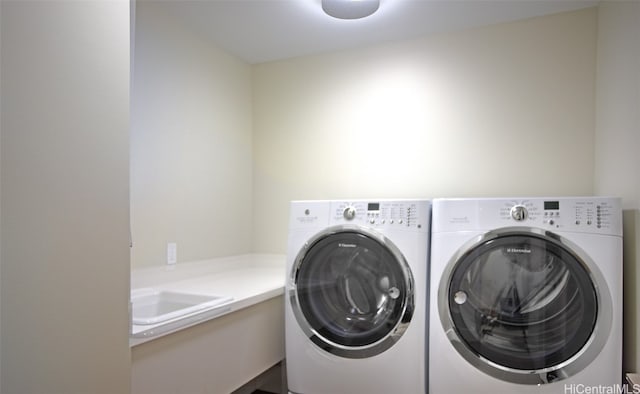 clothes washing area with sink and washing machine and clothes dryer