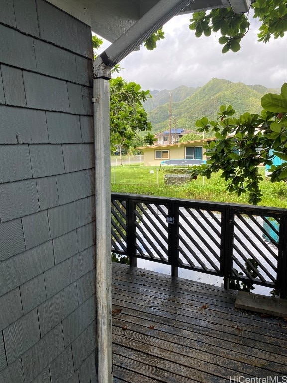 wooden deck featuring a mountain view and a lawn