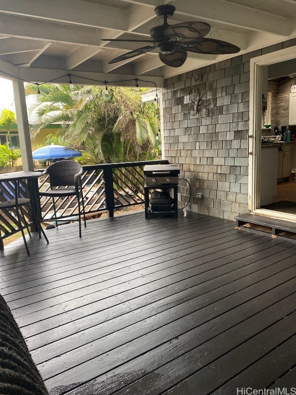 deck featuring area for grilling and ceiling fan