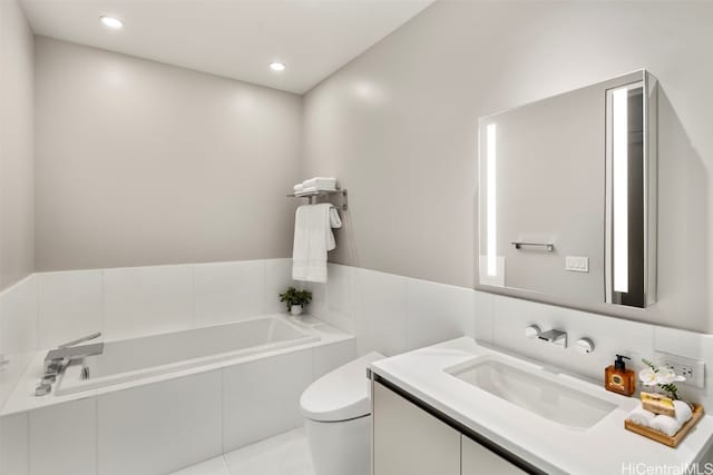 bathroom with vanity, toilet, tiled bath, and tile patterned floors