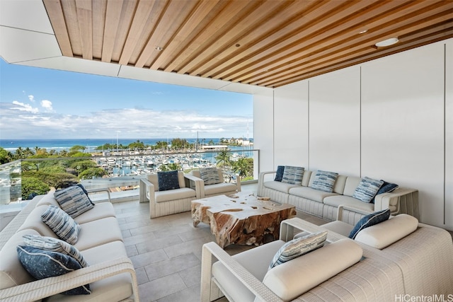 balcony with an outdoor living space and a water view