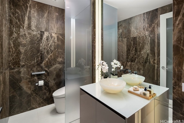 bathroom with vanity, toilet, and tile walls