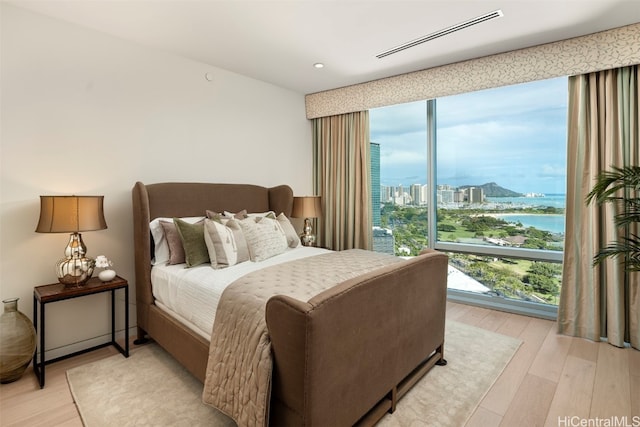 bedroom with a water view and light wood-type flooring