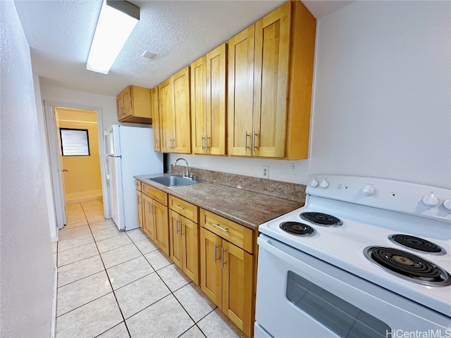 kitchen featuring white appliances, light tile patterned floors, a textured ceiling, and sink