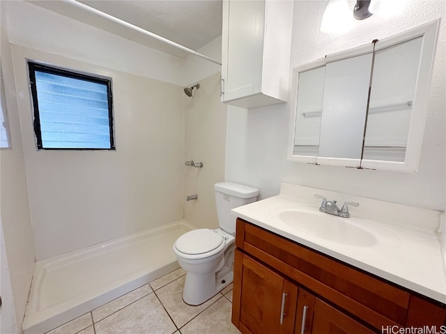 bathroom with vanity, a shower, toilet, and tile patterned flooring