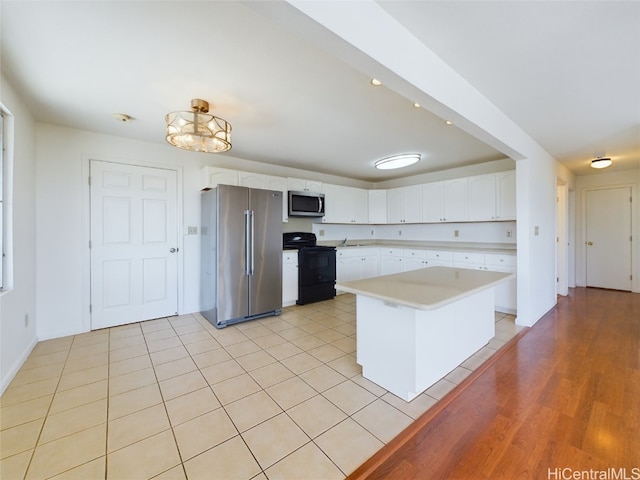 kitchen featuring light hardwood / wood-style floors, a center island, white cabinets, and stainless steel appliances