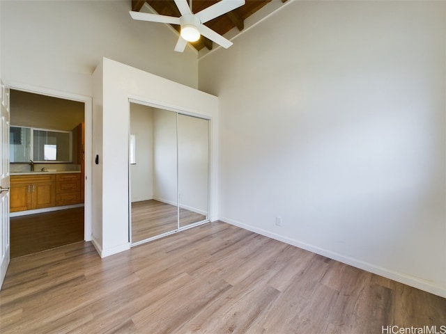 unfurnished bedroom featuring sink, light hardwood / wood-style floors, a closet, and ceiling fan