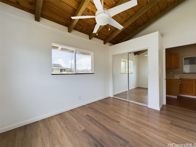 unfurnished bedroom with vaulted ceiling with beams, a closet, wooden ceiling, light wood-type flooring, and ceiling fan