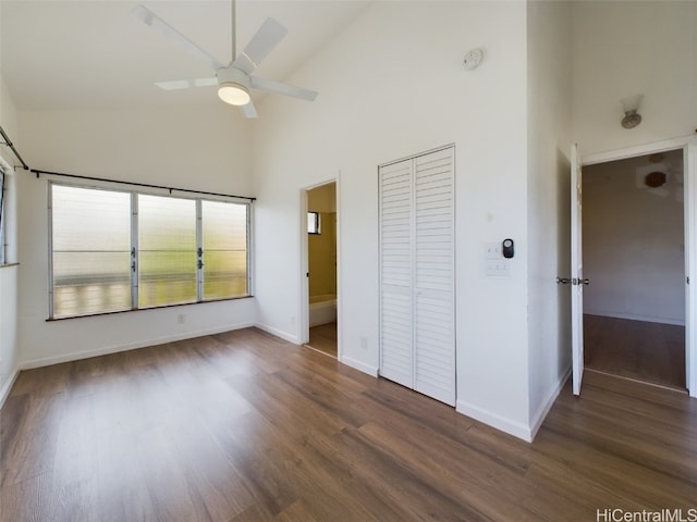 unfurnished bedroom with dark hardwood / wood-style floors, ensuite bath, high vaulted ceiling, and ceiling fan