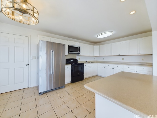 kitchen with light tile patterned flooring, white cabinetry, stainless steel appliances, and hanging light fixtures