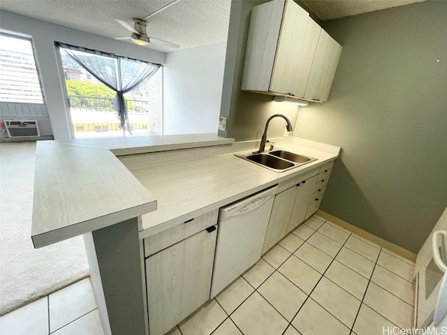 kitchen with light tile patterned floors, a textured ceiling, white dishwasher, and sink