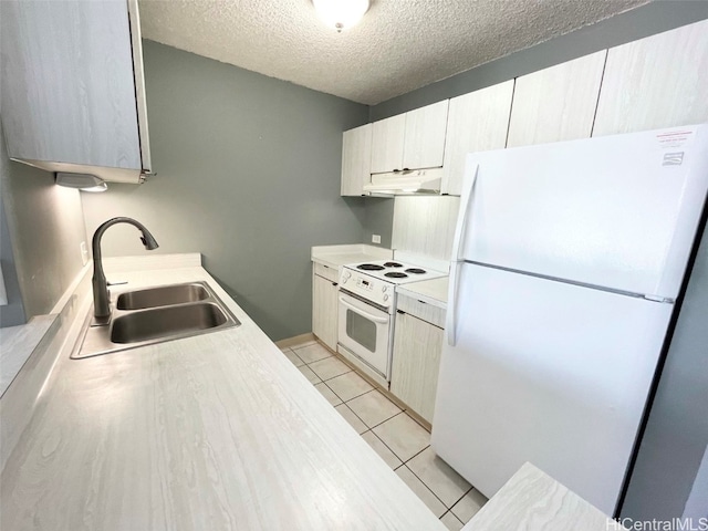 kitchen with a textured ceiling, sink, light tile patterned floors, and white appliances