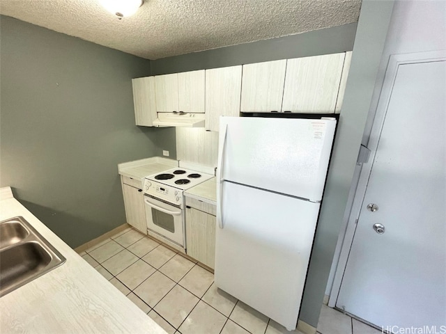 kitchen with white appliances, a textured ceiling, light tile patterned flooring, and sink