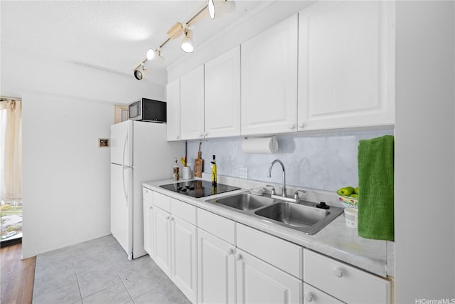 1750 Kalakaua Ave Unit 1611, Honolulu, HI 96826 - kitchen with stainless steel microwave, a sink, black electric stovetop, white cabinets, and light countertops
