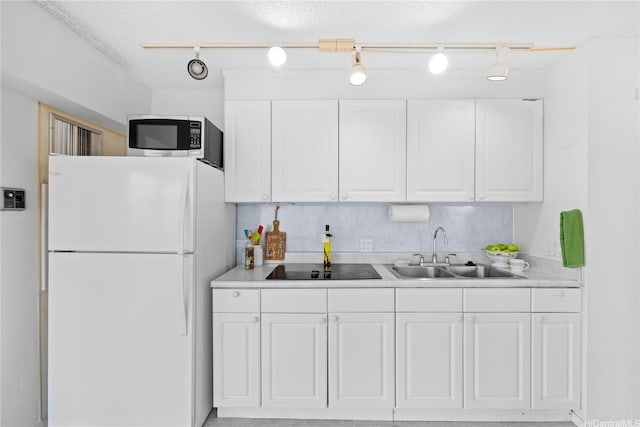 1750 Kalakaua Ave Unit 1611, Honolulu, HI 96826 - kitchen featuring freestanding refrigerator, a sink, stainless steel microwave, white cabinetry, and light countertops