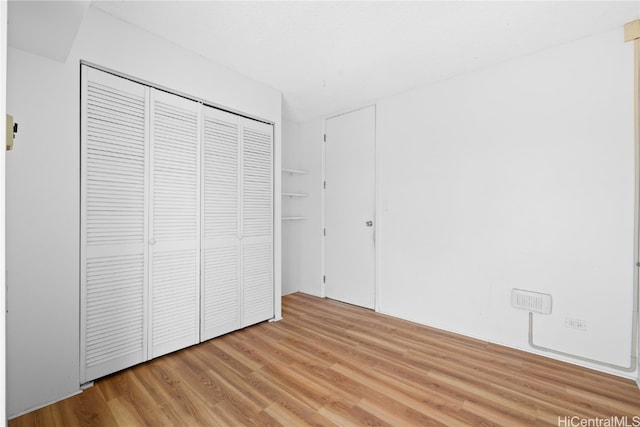 unfurnished bedroom with a closet and light hardwood / wood-style flooring