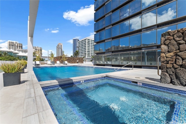 view of swimming pool with a hot tub