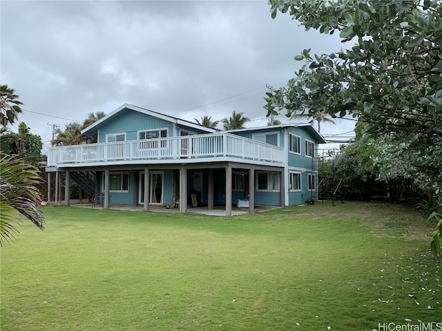 rear view of property featuring a patio, a deck, and a lawn