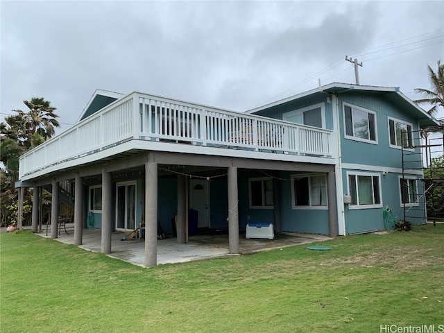 rear view of house featuring a yard, a deck, and a patio