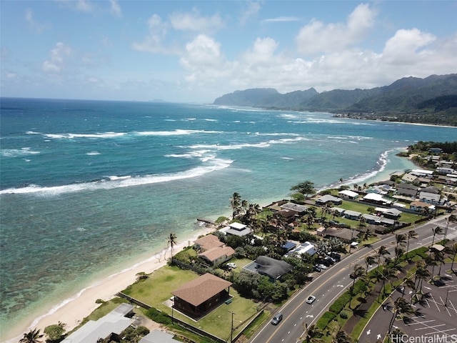 drone / aerial view featuring a water and mountain view and a beach view