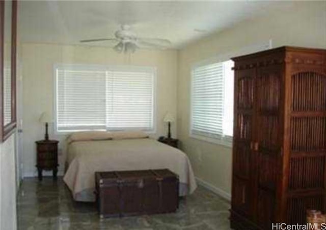 bedroom with ceiling fan and multiple windows