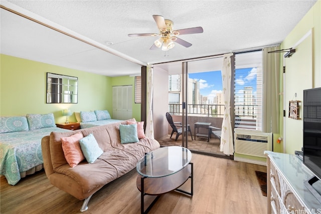 bedroom with light hardwood / wood-style floors, a textured ceiling, access to exterior, and ceiling fan