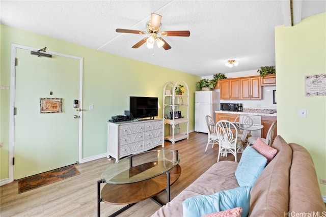 living room with a textured ceiling, light hardwood / wood-style floors, and ceiling fan