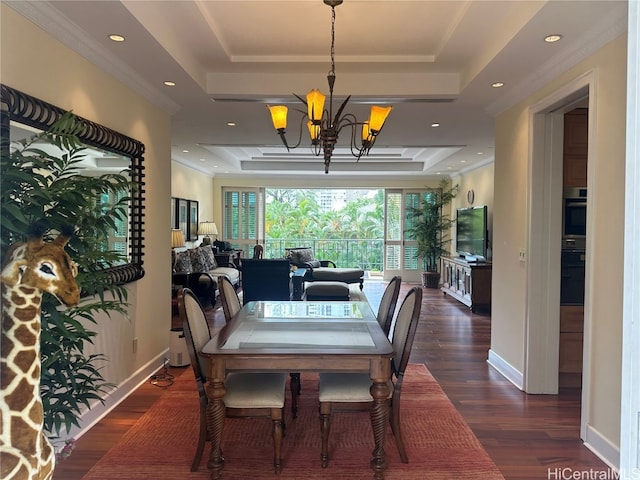 dining room with ornamental molding, dark hardwood / wood-style floors, a chandelier, and a raised ceiling