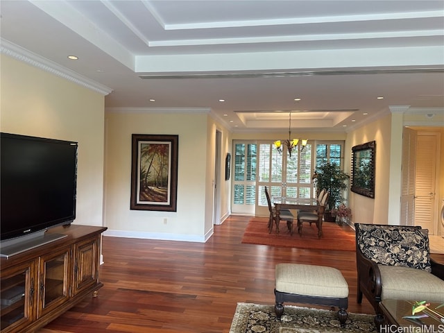 living room featuring crown molding, a notable chandelier, dark hardwood / wood-style floors, and a raised ceiling