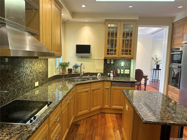 1740 S Beretania St Unit 33, Honolulu, HI 96826 - kitchen featuring a sink, black electric stovetop, light wood-style flooring, wall chimney range hood, and glass insert cabinets