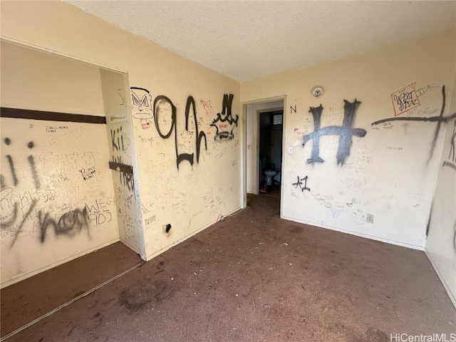 carpeted empty room with a textured ceiling