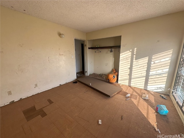 unfurnished bedroom with a textured ceiling and a closet