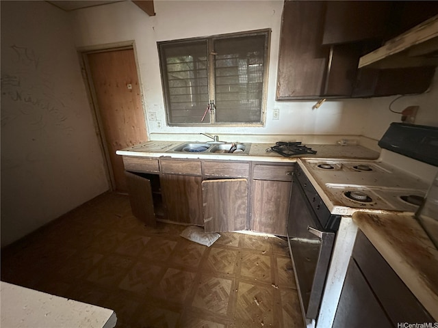 87-213 Helelua Pl Unit 1, Waianae, HI 96792 - kitchen with white range with electric stovetop, a sink, under cabinet range hood, light countertops, and dark flooring