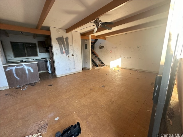 unfurnished living room featuring beamed ceiling and ceiling fan