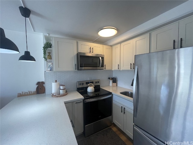 kitchen with kitchen peninsula, stainless steel appliances, white cabinetry, and hanging light fixtures