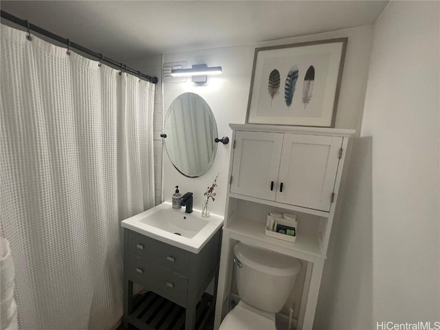 bathroom featuring vanity, toilet, and curtained shower