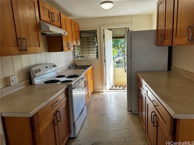 kitchen featuring sink, white range with electric cooktop, and stainless steel refrigerator