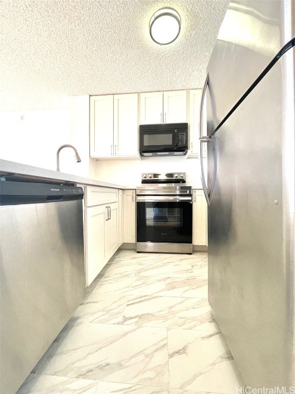 kitchen with white cabinetry, sink, stainless steel appliances, and a textured ceiling