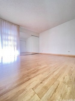 unfurnished room with hardwood / wood-style floors and a textured ceiling