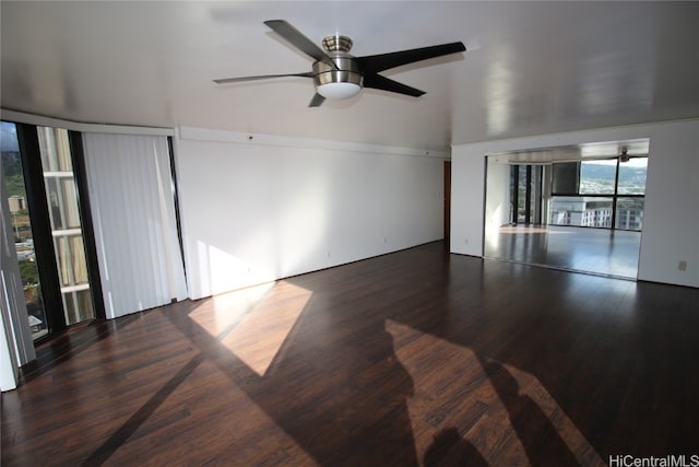 unfurnished living room with dark wood-type flooring and ceiling fan