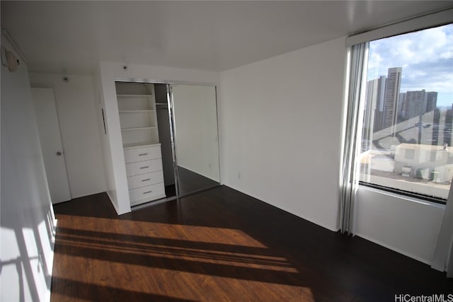 bedroom featuring dark wood-type flooring and a closet