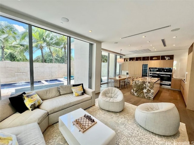 living room with expansive windows, a healthy amount of sunlight, and light hardwood / wood-style flooring