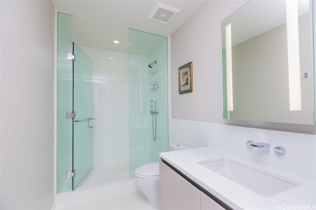 bathroom with tile patterned flooring, vanity, toilet, and a shower with door