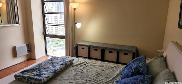 bedroom with light hardwood / wood-style floors and heating unit