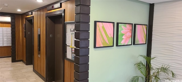 corridor with mail boxes, wooden walls, and elevator