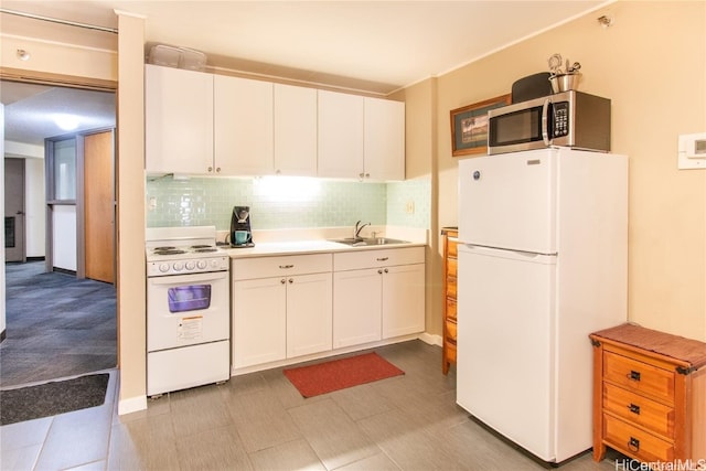 kitchen with white appliances, backsplash, white cabinetry, and sink