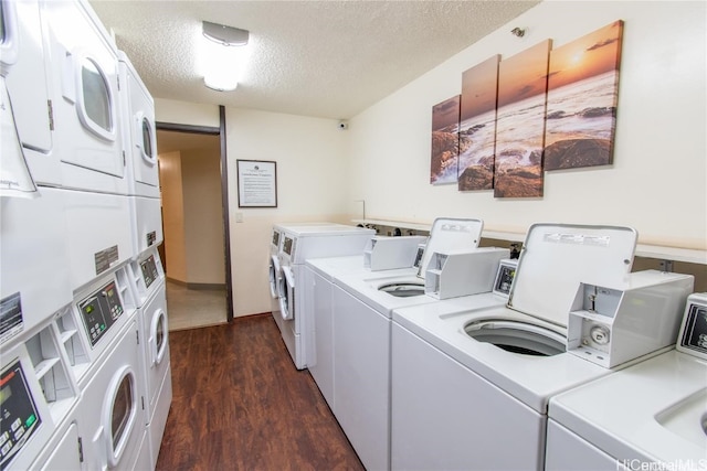 laundry area with a textured ceiling, stacked washer and dryer, dark wood-type flooring, and washing machine and clothes dryer