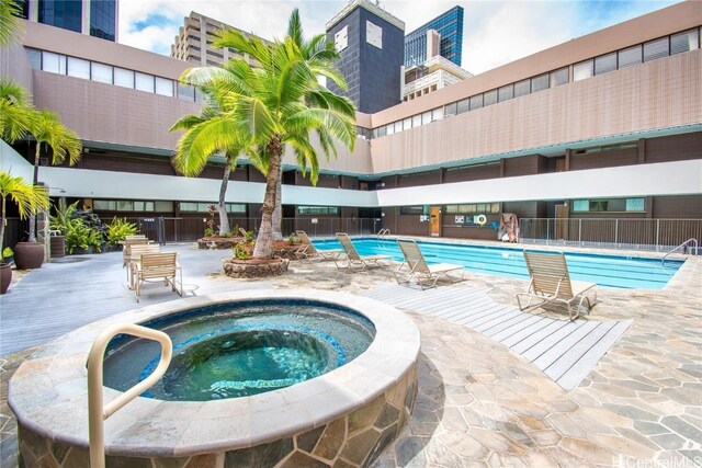 view of swimming pool with a patio area and a community hot tub