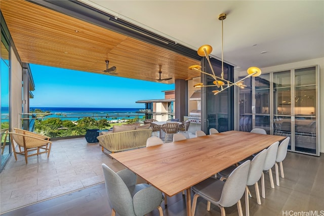 dining area featuring plenty of natural light, wooden ceiling, a water view, and ceiling fan