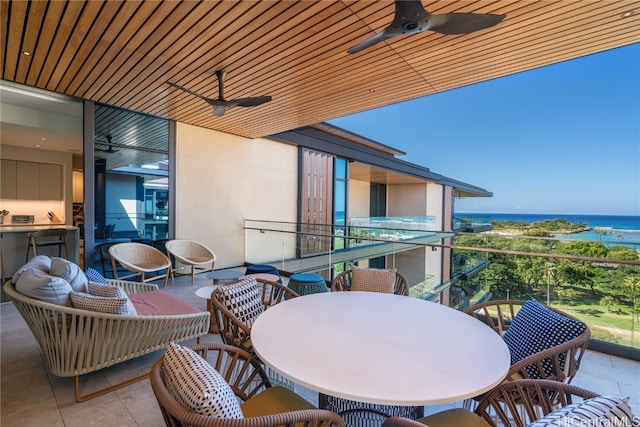 balcony featuring a water view and ceiling fan